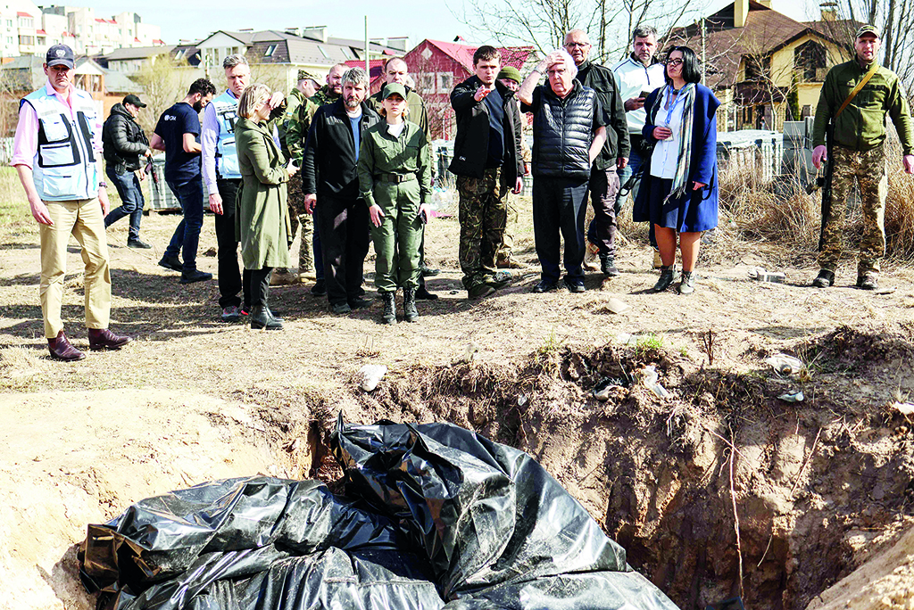BUCHA: UN humanitarian chief Martin Griffiths (5th right) reacts at the site of a mass grave that Ukrainians had dug near a church on April 7, 2022 during his three-hour visit in Bucha, a day after he visited Moscow, where he met with officials to discuss the humanitarian situation in Ukraine.- AFP