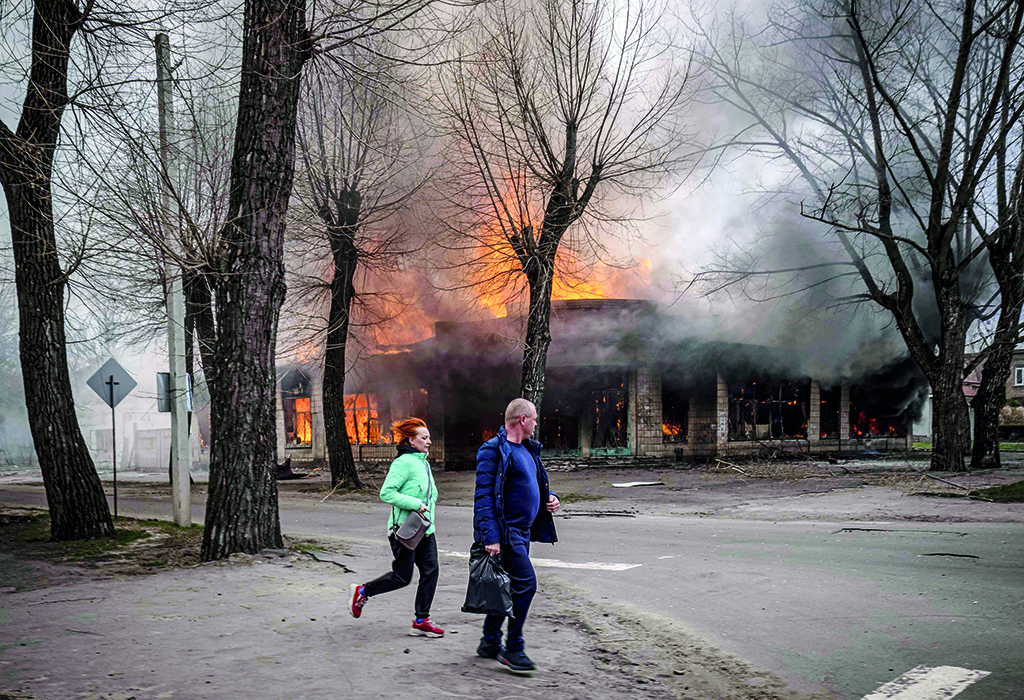 SEVERODONETSK: Residents run near a burning house following a shelling in Severodonetsk, Donbass region, on April 6, 2022, as Ukraine tells residents in the country's east to evacuate 'now or risk death' ahead of a feared Russian onslaught on the Donbas region, which Moscow has declared its top prize. - AFP