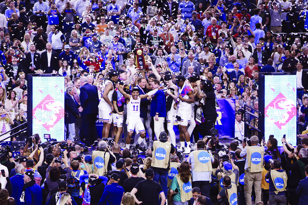 NEW ORLEANS: Kansas Jayhawks players and coaches hold up the trophy after defeating the North Carolina Tar Heels 72-69 during the 2022 NCAA Men's Basketball Tournament National Championship at Caesars Superdome on April 4, 2022. - AFP