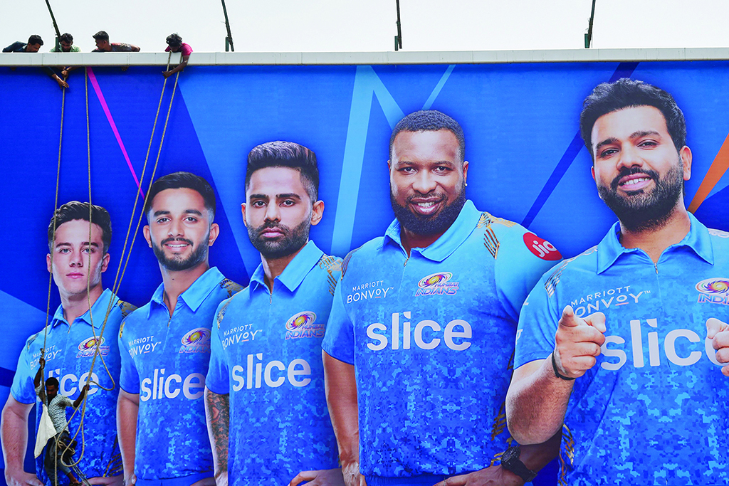MUMBAI: Workers fix a billboard displaying pictures of Mumbai Indians team members for the Indian Premier League's (IPL) in Mumbai.- AFP