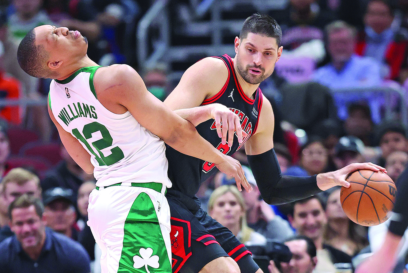 CHICAGO: Nikola Vucevic #9 of the Chicago Bulls moves against Grant Williams #12 of the Boston Celtics after a collision at the United Center on April 6, 2022. - AFP