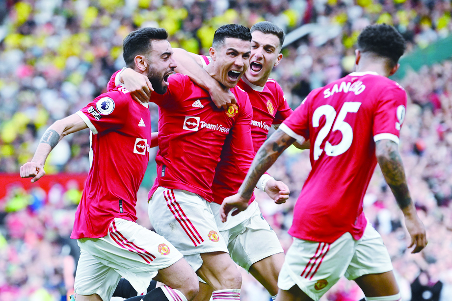 MANCHESTER: Manchester United's Portuguese striker Cristiano Ronaldo celebrates with teammates after scoring his third goal during the English Premier League football match against Norwich City at Old Trafford on April 16, 2022. - AFP
