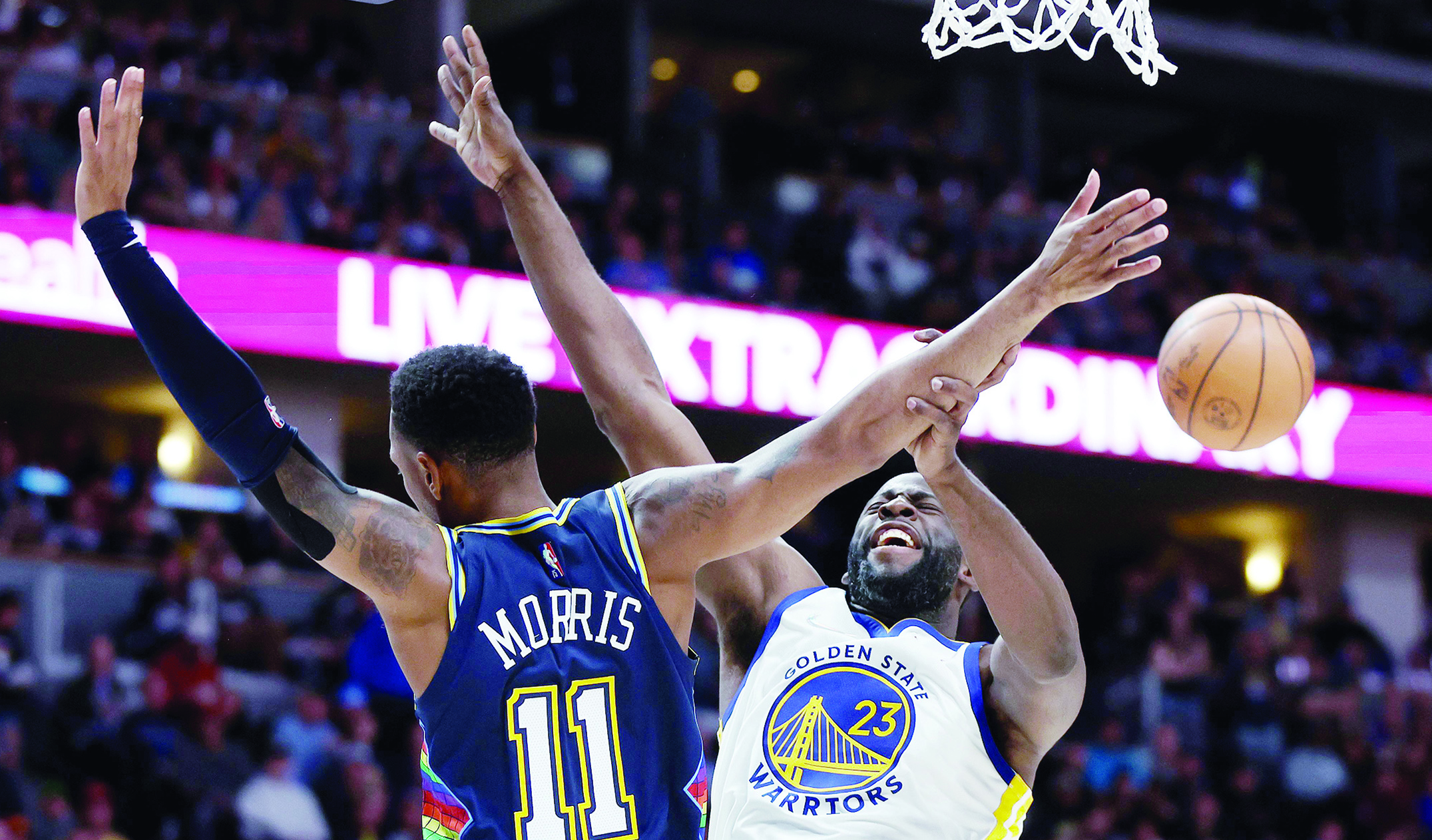 DENVER: Monte Morris #11 of the Denver Nuggets collides under the basket with Draymond Green #23 of the Golden State Warriors in the third quarter during Game Four of the Western Conference First Round NBA Playoffs at Ball Arena on April 24, 2022. - AFP