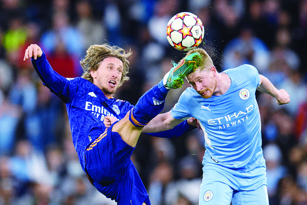 MANCHESTER: Real Madrid's Croatian midfielder Luka Modric fights for the ball with Manchester City's Belgian midfielder Kevin De Bruyne during their UEFA Champions League semifinal first leg match at the Etihad Stadium on April 26, 2022. - AFP
