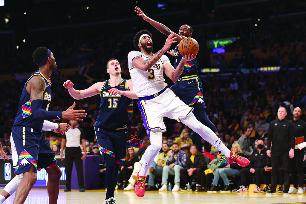 LOS ANGELES: Anthony Davis #3 of the Los Angeles Lakers splits the defense of Davon Reed #9 and Nikola Jokic #15 of the Denver Nuggets during the second half of a game at Crypto.com Arena on April 3, 2022. - AFP