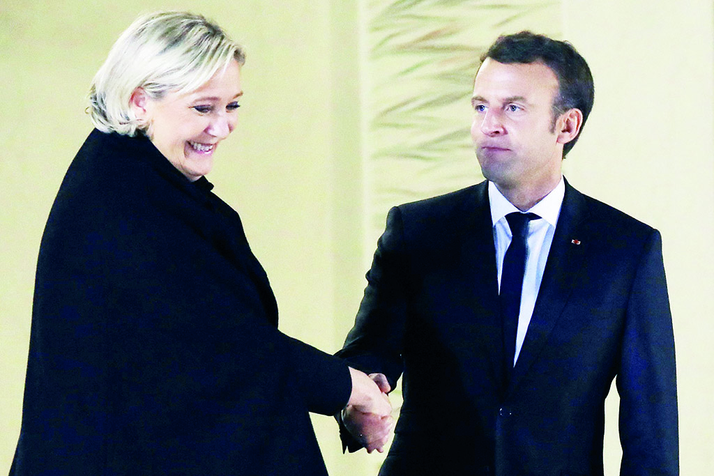 PARIS: Marine Le Pen (left) shakes hands with French President Emmanuel Macron after their meeting at the Elysee palace in this file photo. - AFP
