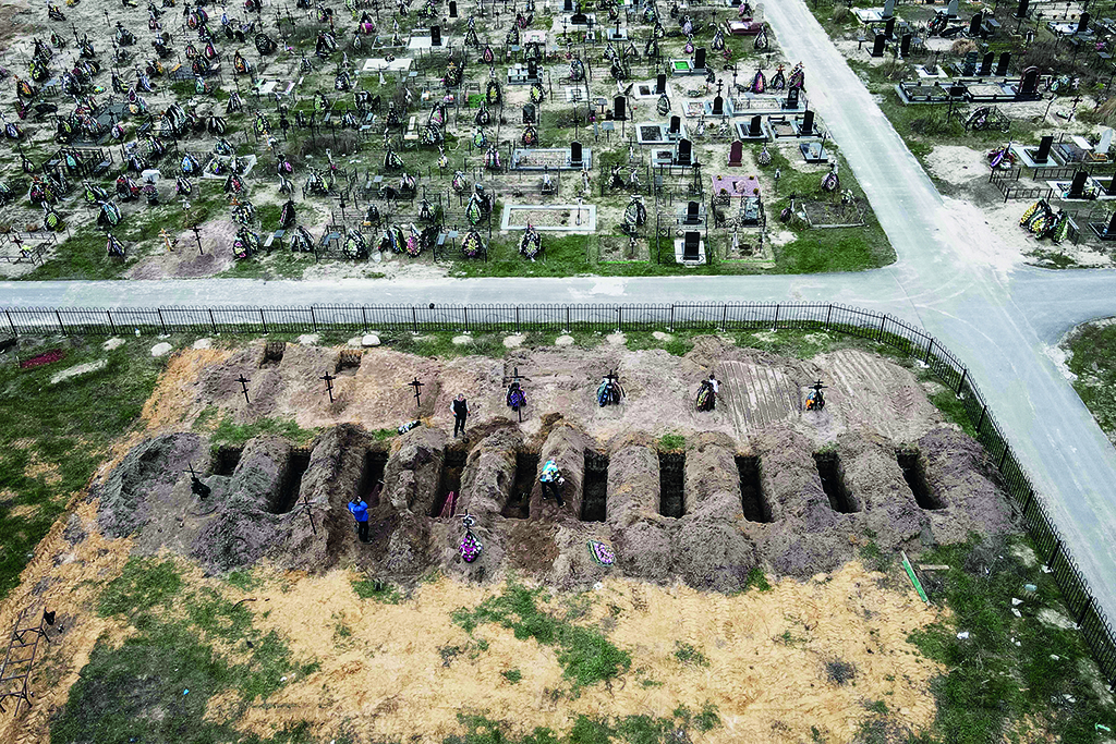 BUCHA: An aerial picture taken shows coffins being buried during a funeral ceremony at a cemetery in Bucha, Ukraine, amid the Russian invasion. - AFP