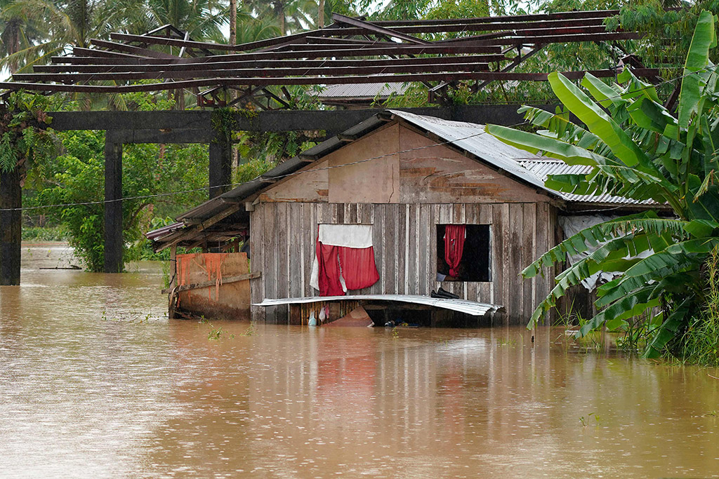 ABUYOG, Philippines: Residents look outside the window of their submerged house after heavy rains brought about by Tropical storm Agaton in Abuyog town, Leyte province, southern Philippines on April 11, 2022. - AFP