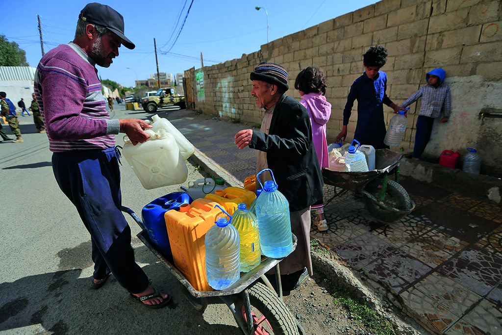 SANAA: Yemenis fill their jerrycans with drinking water from a donated tank amid acute shortage in the capital Sanaa. The World Bank estimates just half of Yemen's medical facilities are fully functional, and that 80 percent of the population have problems accessing food, drinking water and health services. - AFP
