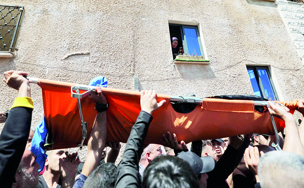 JENIN: Women watch from a window as mourners carry the body of 25-year-old Palestinian Ahmed Al-Saadi, who was killed earlier during clashes with Zionist forces. - AFP