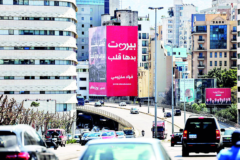 BEIRUT: Vehicles drive in the centre of Lebanon's capital Beirut, while the background shows a giant billboard for the upcoming parliamentary election.- AFP