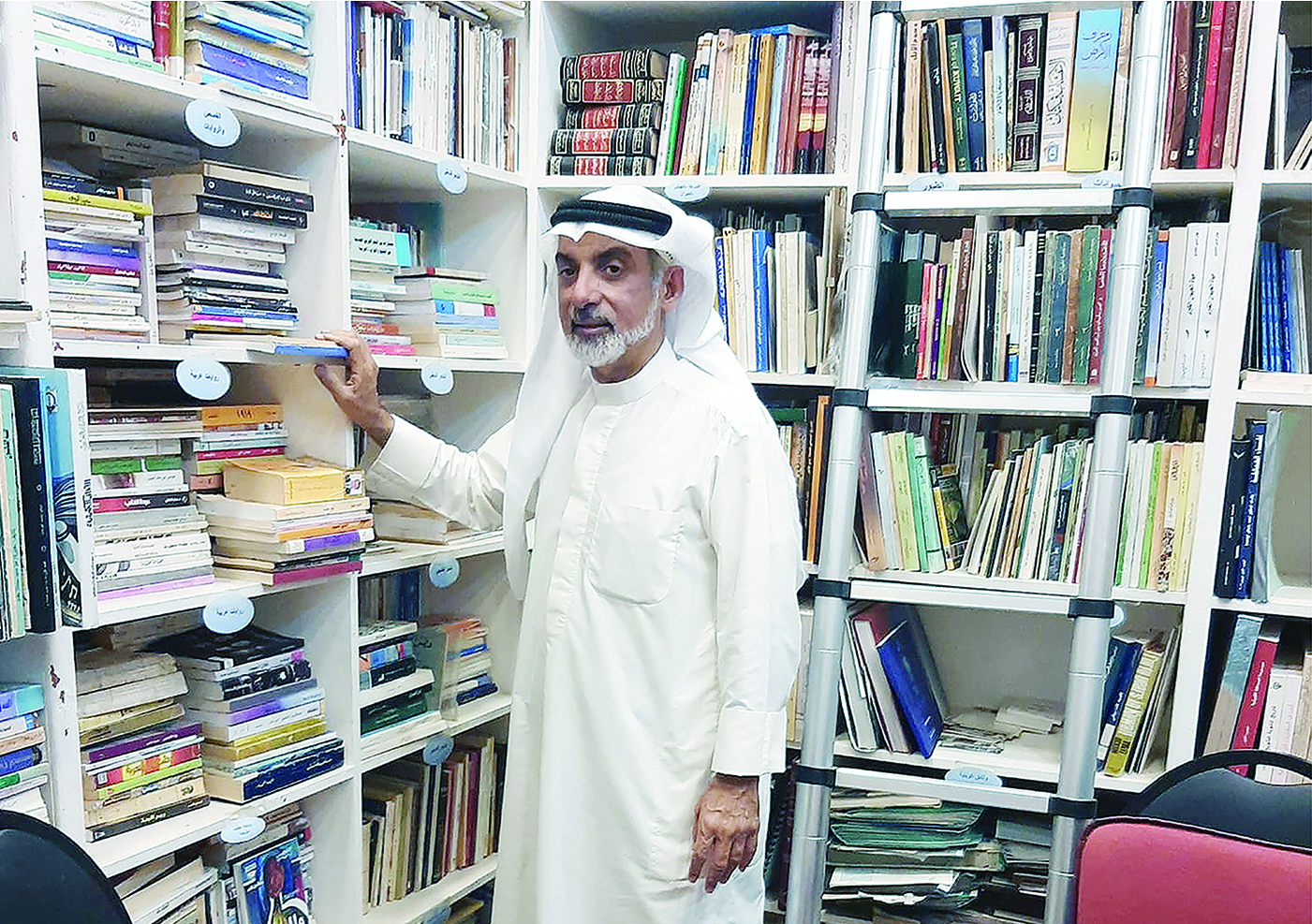 KUWAIT: Saleh Al-Misbah poses with some of his books in the Kuwait Heritage Library. - Photo by Yasser Al-Zayyat