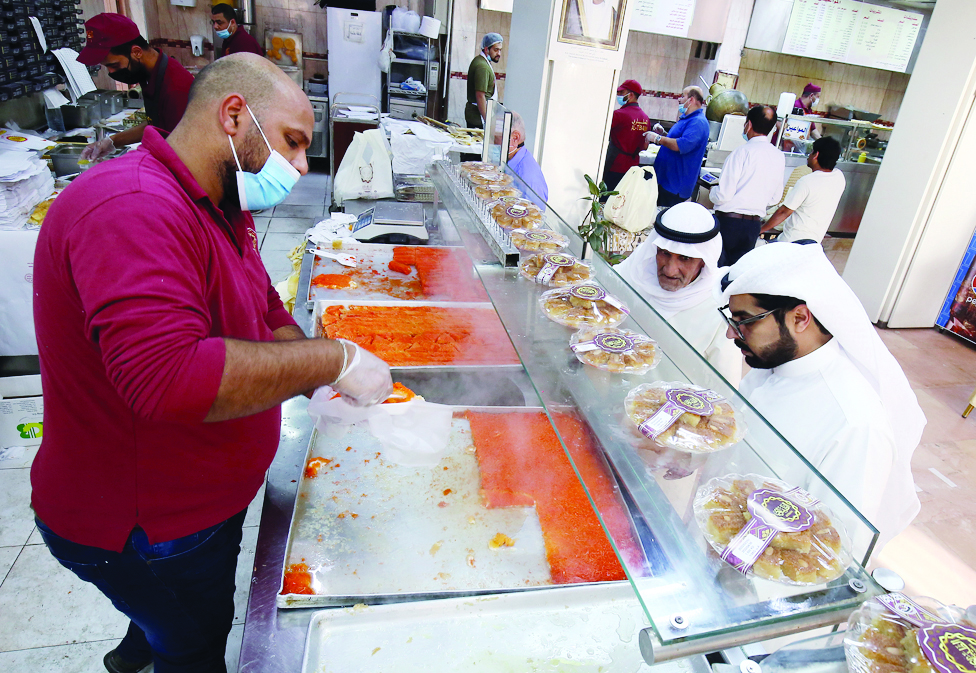 KUWAIT: Workers prepare sweets for customers at a shop in Kuwait on the second day of the Muslim holy fasting month of Ramadan on April 3, 2022. Various types of Arabic sweets including Qatayef and Kunafa are usually presented to guests during ghabqas. – Photos by Yasser Al-Zayyat