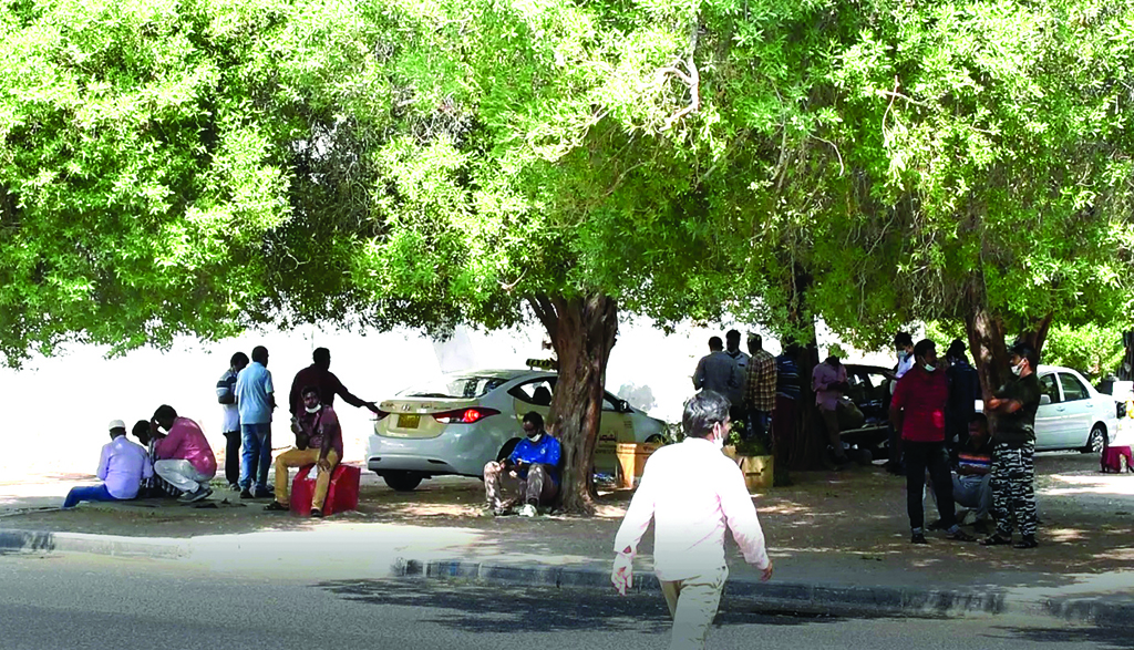 KUWAIT: This file photo shows workers taking shelter under a tree in Kuwait. – Photo by Fouad Al-Shaikh