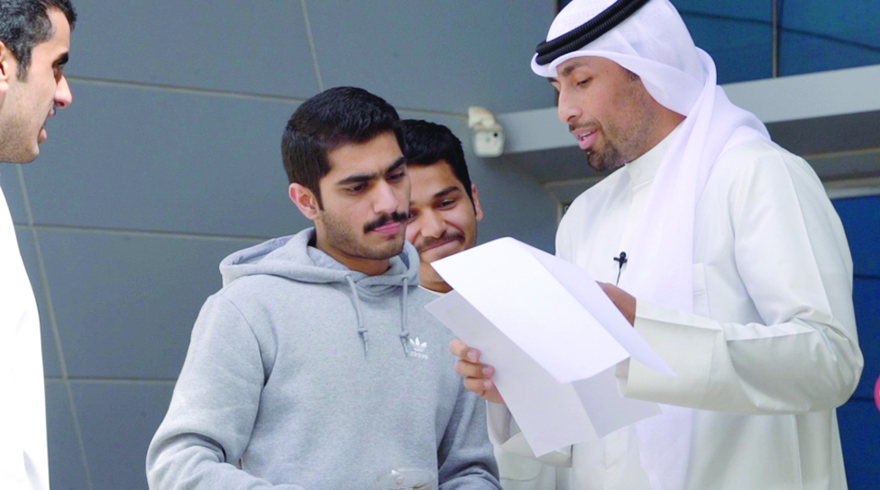 KUWAIT: Public Relations representative at KFH Muhammad Al-Awadhi gives an explanation to some students.