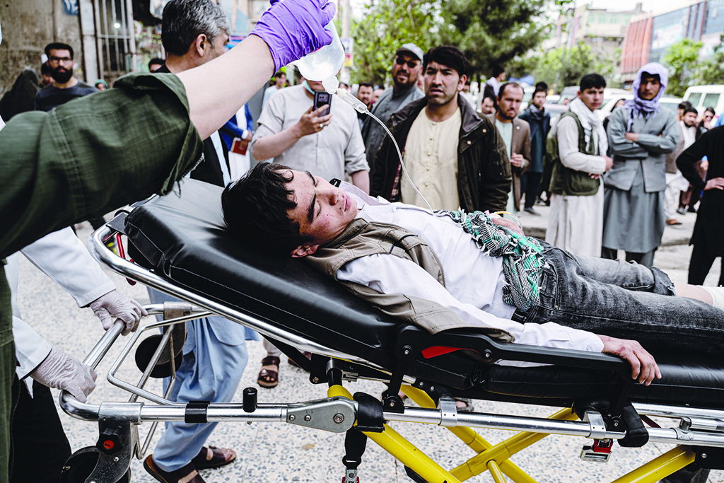 KABUL: Medical staff move a wounded youth on a stretcher outside a hospital in Kabul on April 19, 2022, after two bomb blasts rocked a boys' school in a Shiite Hazara neighbourhood killing at least 6 people.-AFP