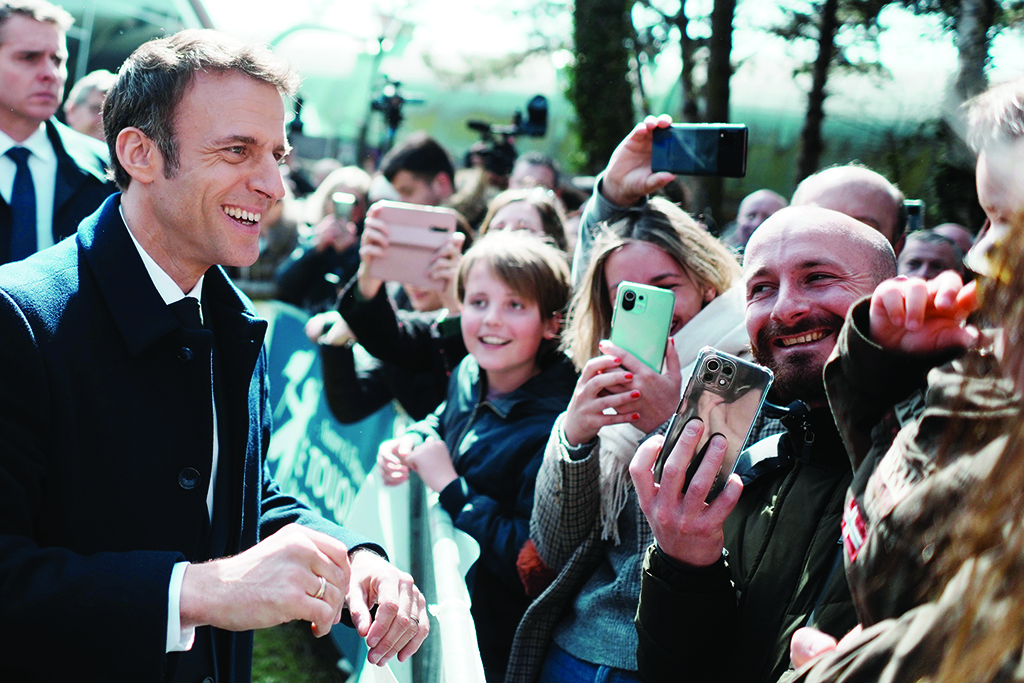 LE TOUQUET, France: France's President and LREM party presidential candidate Emmanuel Macron smiles to residents after voting for the first round of France's presidential election at a polling station in Le Touquet, northern France on April 10, 2022.- AFP