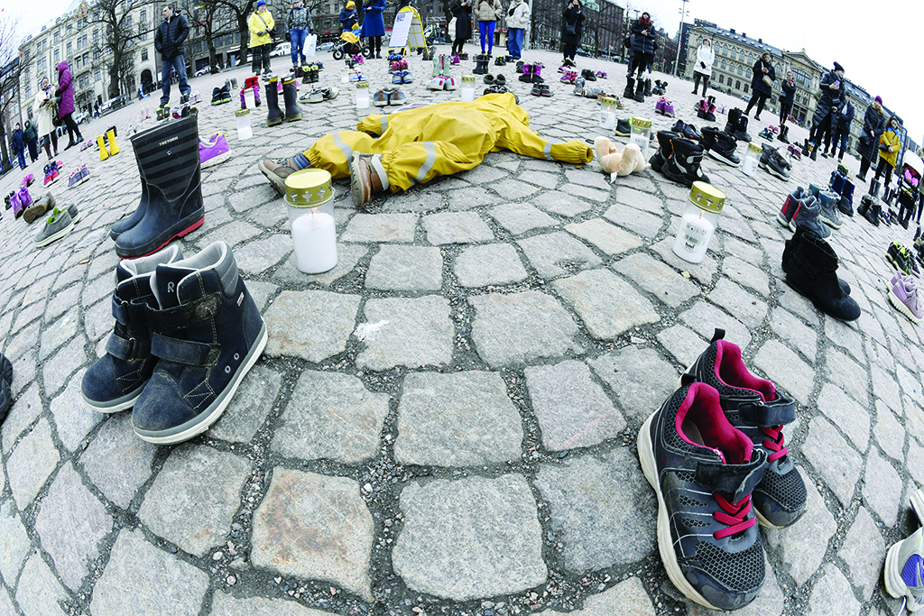 HELSINKI, Finland: Candles, children's clothing and shoes are seen during a demonstration organized by the Ukrainian Association in Finland, to honor the memory of the children killed in Mariupol, Ukraine, in Helsinki, on April 10, 2022. - AFP