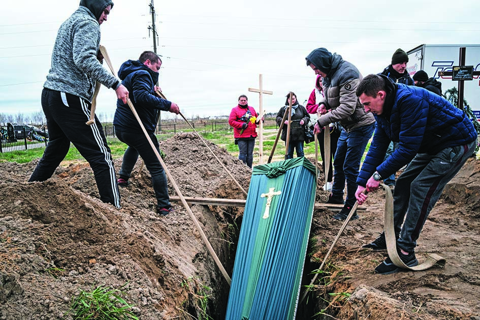 BUCHA, Ukraine: Relatives of Mykhailo Romaniuk, 58, who was shot dead on his bicycle on March 6, help to bury his coffin at a cemetery in Bucha, on April 19, 2022, during the Russian invasion of Ukraine.—AFP