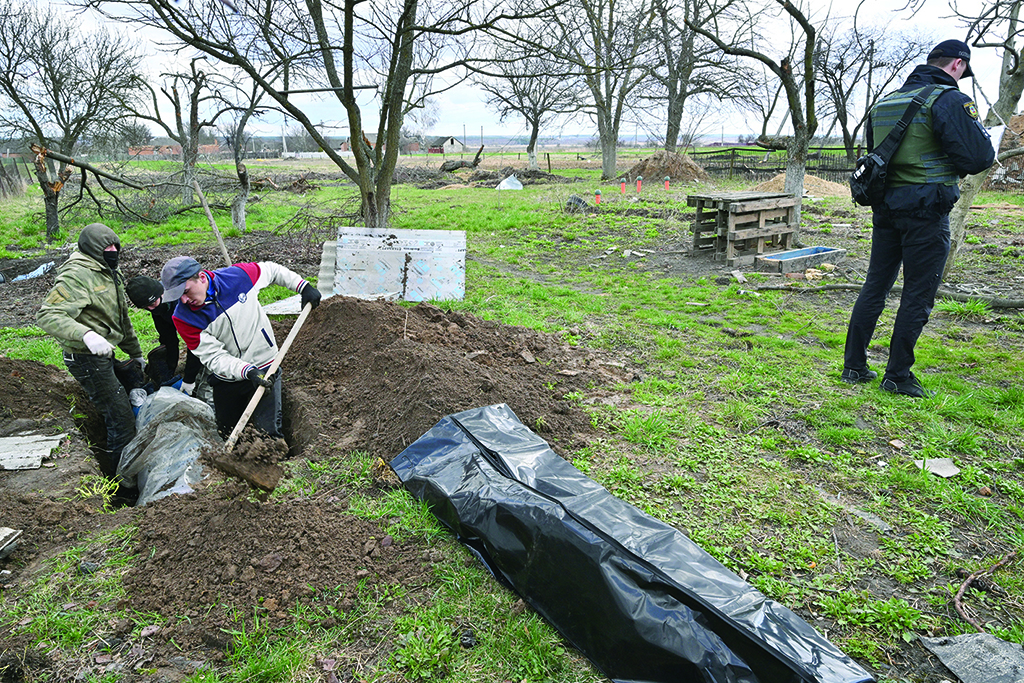ANDRIIVKA, Ukraine: Communal workers exhume a body of a man buried near his house in Andriivka village, Kyiv region. – AFP
