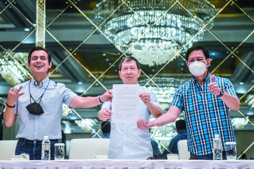 MAKATI: (L-R) Philippine presidential candidates Manila City Mayor Francisco Domagoso, former defence secretary Norberto Gonzales, and senator Panfilo Lacson show a signed copy of their joint statement during a press conference in Makati City, suburban Manila. - AFP