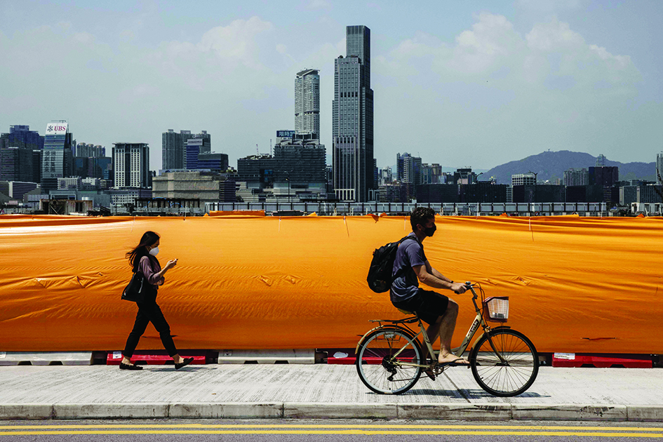 HONG KONG: A man rides a bicycle next to Victoria Harbor in Hong Kong on April 7, 2022. - AFP