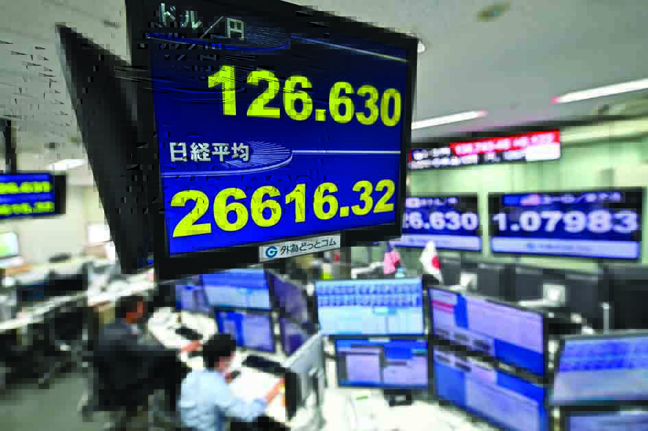 TOKYO: An electronic quotation board displays the yen's rate against the US dollar (center top) and the share price of the Tokyo Stock Exchange (center bottom) at a foreign exchange brokerage in Tokyo on April 18, 2022. – AFP