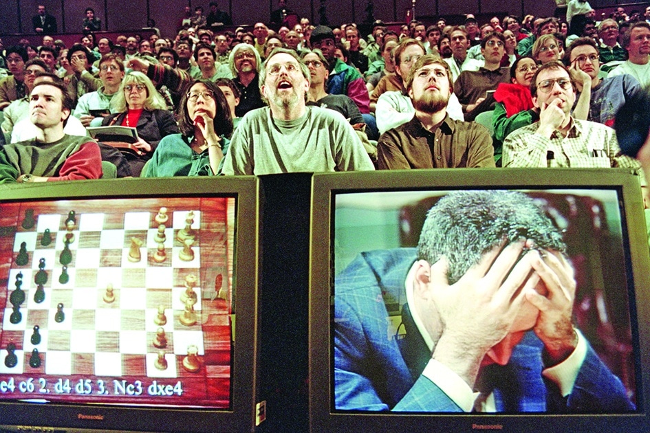 In this file photo taken on May 11, 1997 Chess enthusiasts watch World Chess champion Garry Kasparov on a television monitor as he holds his head in his hands at the start of the sixth and final match May 11, 1997 against IBM's Deep Blue computer in New York.—AFP photos