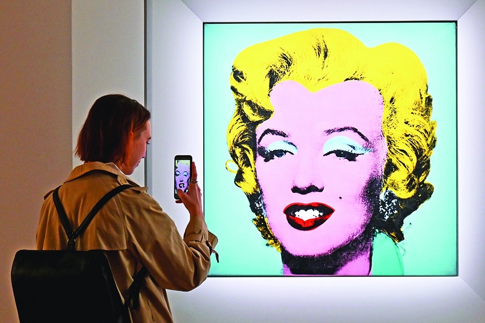 In this file photo a woman takes a photo of Andy Warhol’s ‘Shot Sage Blue Marilyn’ during Christie’s 20th and 21st Century Art press preview at Christie’s New York in New York City.—AFP