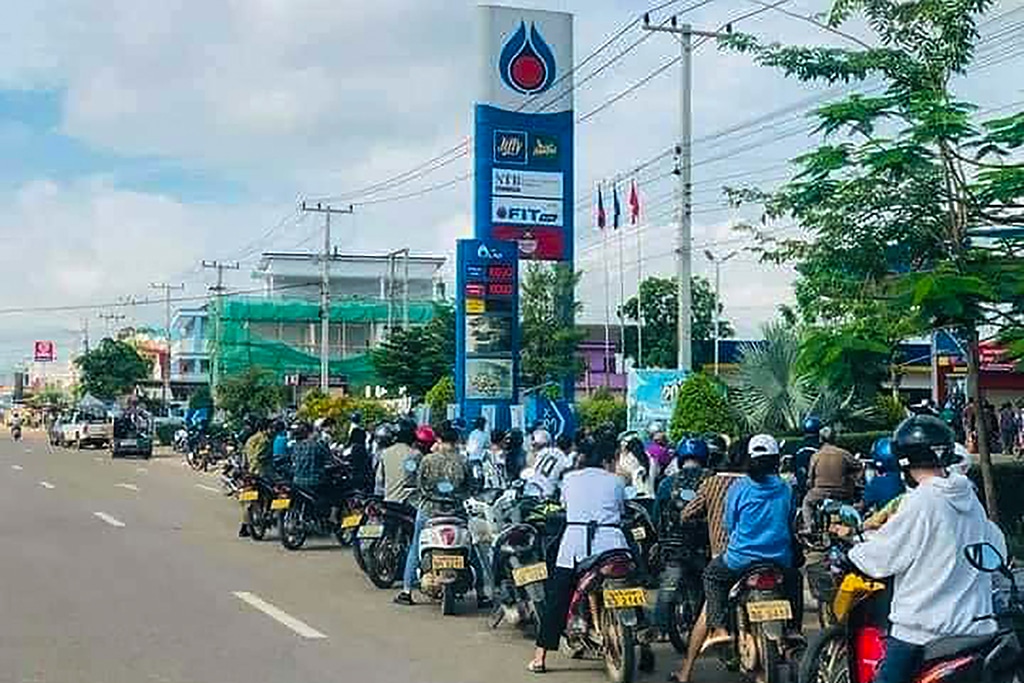 VIENTIANE, Laos: This picture from Lao National TV taken between May 9 and 10, 2022 and released on May 10, 2022 shows motorists queuing to pump fuel into their vehicles at a petrol station in Vientiane. - AFP