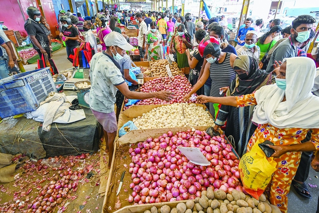 COLOMBO: People buy vegetables at a market after authorities relaxed the ongoing curfew for a few hours in Colombo on May 12, 2022. - AFP photos