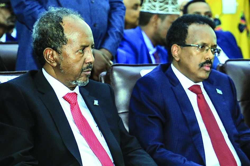 Newly elected Somalia President Hassan Sheikh Mohamud (L) sits next former president Mohamed Abdullahi Mohamed in the capital Mogadishu, on May 16, 2022. - Somalia handed Hassan Sheikh Mohamud the presidency for a second time following May 15's long-overdue election in the troubled Horn of Africa nation, which is confronting an Islamist insurgency and the threat of famine. (Photo by Hasan Ali Elmi / AFP)