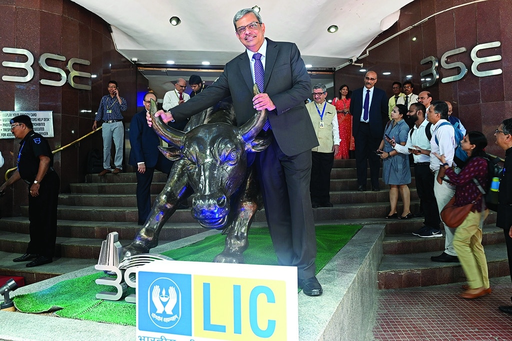 MUMBAI, India: Mangalam Ramasubramanian Kumar (center), chairman of the Life Insurance Corporation of India (LIC), poses with the bronze statue of a bull at the Bombay Stock Exchange (BSE) in Mumbai on May 17, 2022. -- AFP