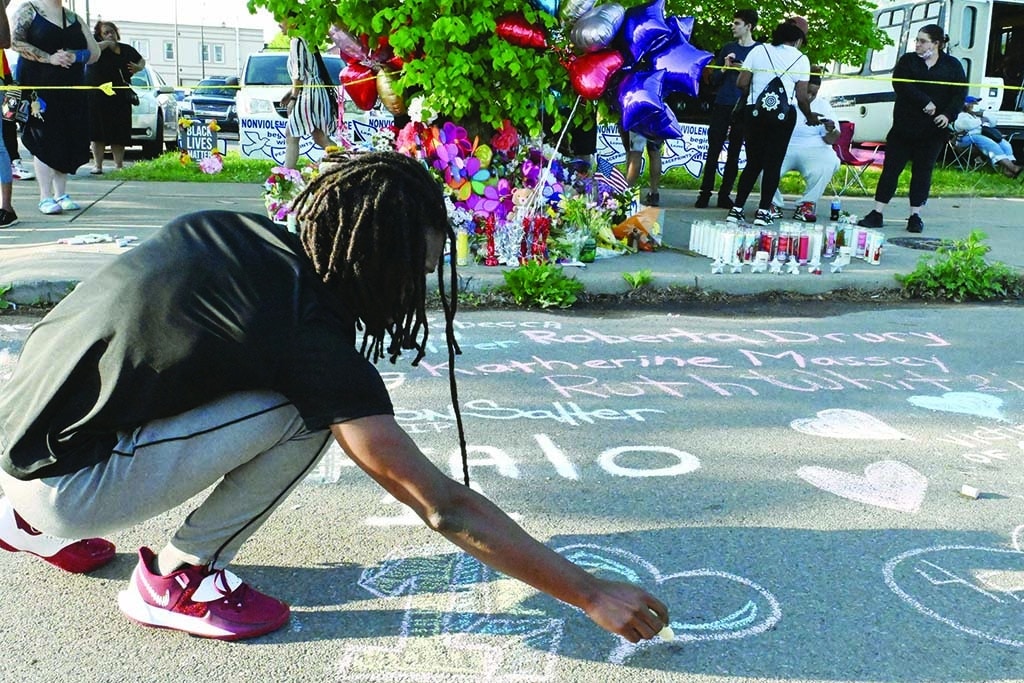 BUFFALO: People leave messages at a makeshift memorial near a Tops Grocery store in Buffalo, New York, the day after a gunman shot dead 10 people. Grieving residents from the US city of Buffalo held vigils after a white gunman shot dead 10 people at a grocery store in a racially-motivated rampage. - AFP