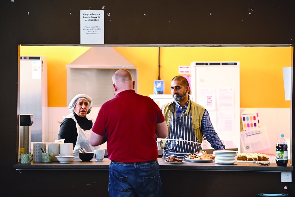 Volunteers work in the kitchen of Bradford Central Foodbank in Bradford, northern England on May 24, 2022.