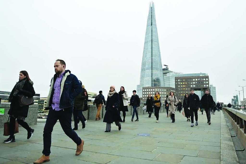 LONDON, UK: In this file photo taken on January 27, 2022, pedestrians on their way to work cross the London Bridge backdropped by The Shard in central London. Britain's unemployment rate has fallen further to a near five-decade low, official data showed May 17, 2022, but the value of wages continues to erode as inflation soars. - AFP