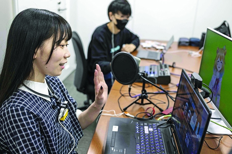 Mayu Iizuka, a virtual YouTuber who voices and animates a character called Yume Kotobuki, hosting a livestream at a studio in Tokyo. - AFP