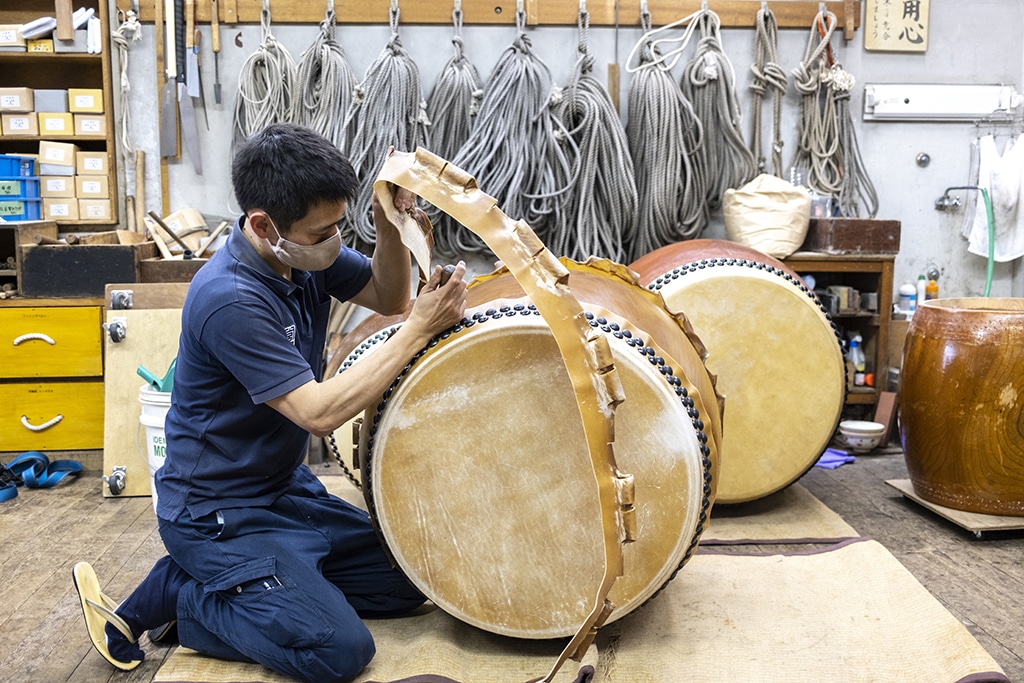 This photo taken on April 26, 2022 shows a craftsperson working on the renovation of a Japanese taiko drum at the Miyamoto Unosuke workshop in Tokyo.