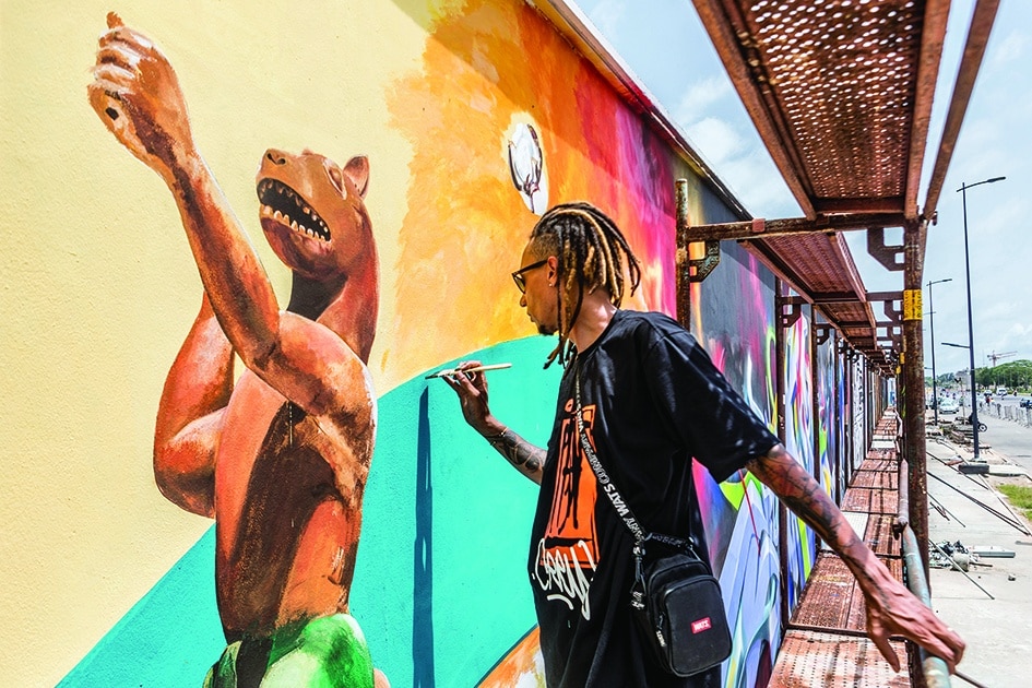 Brazilian artist Dos Santos Edgar Bernado, also known as Ed-mun, paints a mural.