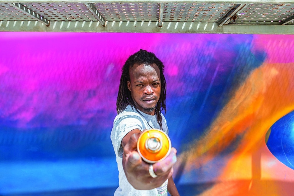 Beninese artist Laurenson Djihouessi, also known as Mr Stone, poses with a spray can.