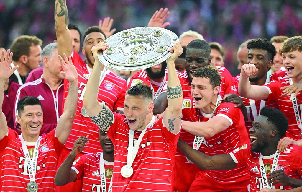 MUNICH: Bayern Munich players including Bayern Munich’s German defender Niklas Suele (center) celebrate with the trophy after the German first division Bundesliga football match between FC Bayern Munich and VfB Stuttgart in Munich, southern Germany on May 8, 2022. - AFP