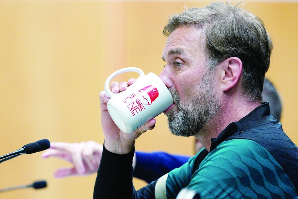 LIVERPOOL: Liverpool's German manager Jurgen Klopp drinks from a mug with the words 'The Normal One' written on it during a press conference at their training ground on May 25, 2022. - AFP