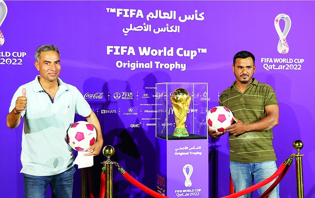 DOHA: People pose next to the World Cup original trophy on display in the Qatari capital on May 6, 2022. - AFP