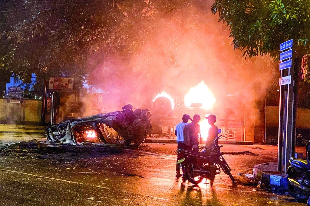 COLOMBO: A vehicle belonging to security personnel and a bus are set alight near Sri Lanka's outgoing Prime Minister Mahinda Rajapaksa's official residence on May 9, 2022. - AFP