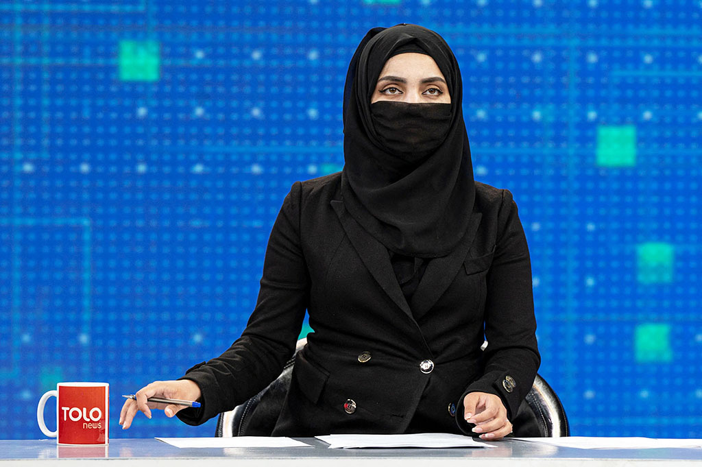 KABUL: A female presenter for Tolo News, Thamina Usmani, covers her face during a live broadcast at Tolo TV station on May 22, 2022. - AFP