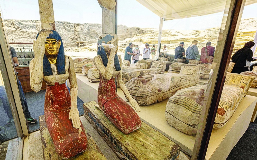 SAQQARA, Egypt: Statuettes depicting Egyptian goddesses Isis and Nephthys and other sarcophaguses found in a cache dating to the Egyptian Late Period are displayed after their discovery at the Bubastian cemetery at the Saqqara necropolis on May 30, 2022. - AFP
