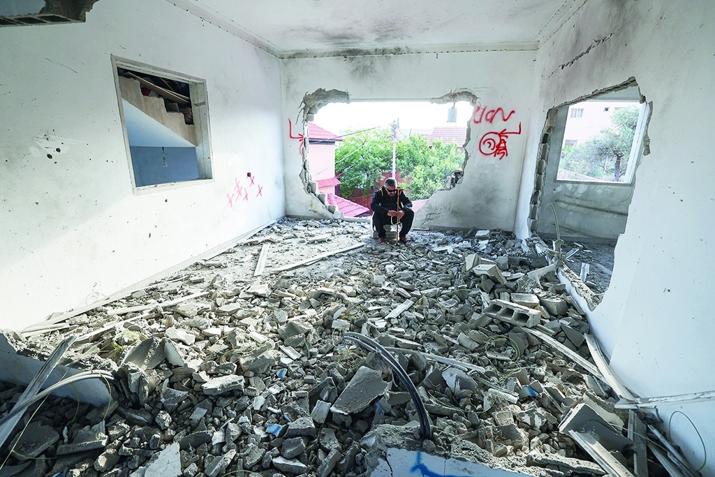 A Palestinian man sits in a house demolished by Israeli security forces in the village of Silat al-Harithiya, near the flashpoint town of Jenin in the occupied West Bank, early on May 7, 2022, belonging to Omar Jaradat accused of killing an Israeli settler the wildcat settlement outpost of Homesh on December 16, when gunmen sprayed a car with around a dozen bullets as it drove out of the wildcat settlement outpost of Homesh. (Photo by JAAFAR ASHTIYEH / AFP)