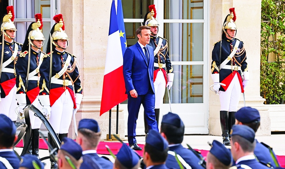 PARIS: Emmanuel Macron (C) reviews troops at the Elysee presidential palace in Paris on May 7, 2022, during his investiture ceremony as French President, following his re-election last April 24.—AFP