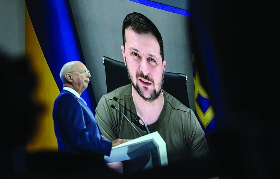 DAVOS: Ukrainian President Volodymyr Zelensky is seen on a giant screen next to Founder and executive chairman of the World Economic Forum Klaus Schwab during his address by video conference as part of the World Economic Forum (WEF) annual meeting in Davos on May 23, 2022. - AFP