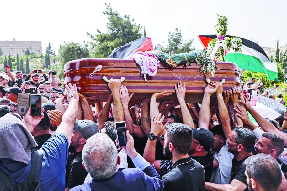JERUSALEM: Palestinian mourners carry the casket of slain Al-Jazeera journalist Shireen Abu Aklel from a church toward the cemetery, during her funeral procession in Jerusalem, on May 13, 2022. - AFP